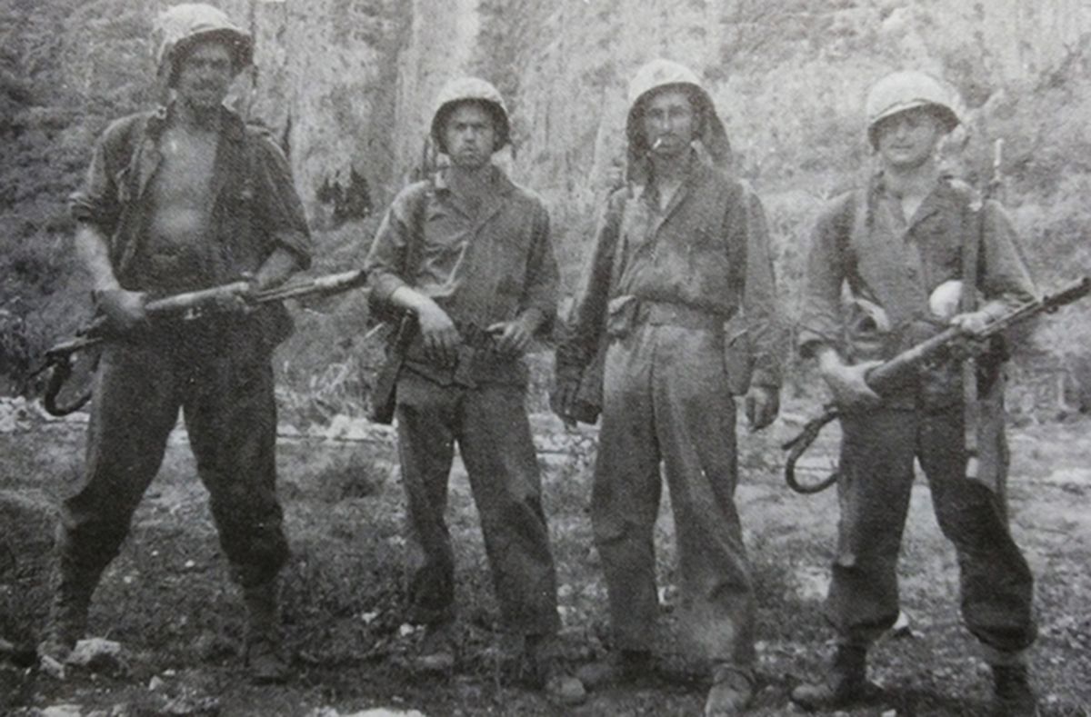 1944年7月,「塞班岛战役」期间,太平洋战场塞班岛最北端马尔皮角,距日军司令部和日本人自杀的悬崖几百英尺处,四名美国海军陆战队第4师突击连士兵的合影,其中有两名拿着M2型火焰喷射器的火焰喷射兵。