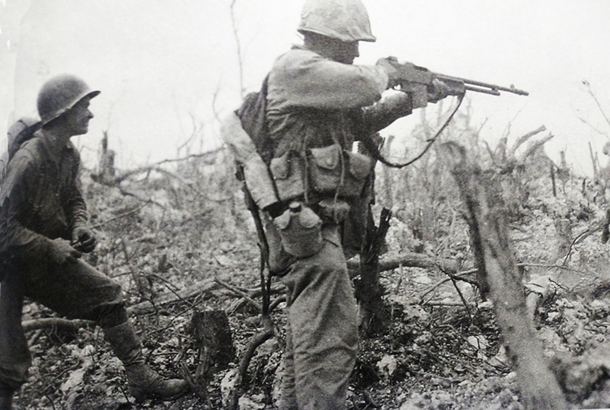 1945年春,「冲绳岛战役」期间,太平洋战场冲绳岛,美国海军陆战1师一名士兵手持M1918「勃朗宁」自动步枪向日军射击,另一名士兵则手拿着一枚MK2手榴弹,随时准备投掷。