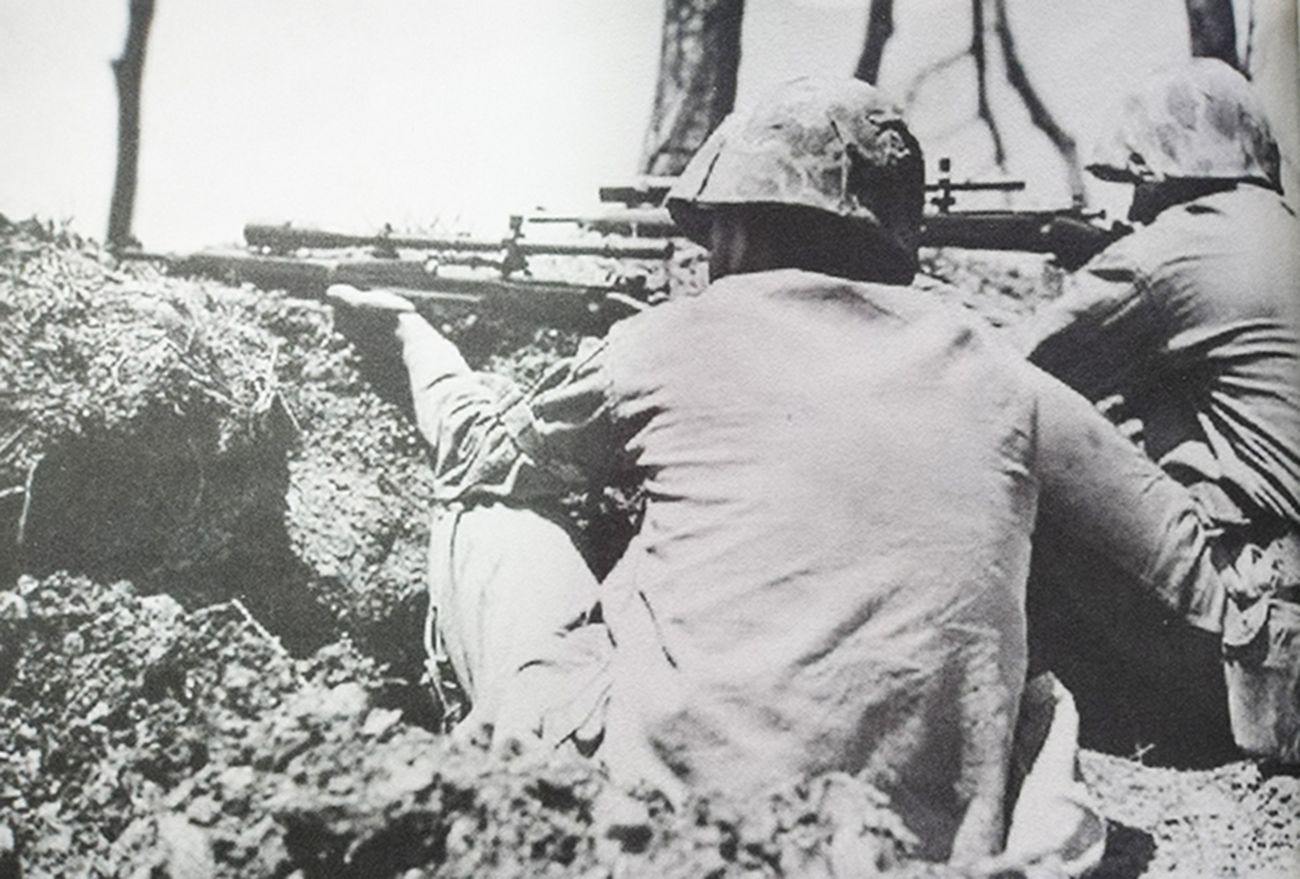 1945年，「冲绳岛战役」期间，太平洋战场冲绳岛，美国海军陆战队的狙击手使用M1903A4狙击步枪猎杀日军。