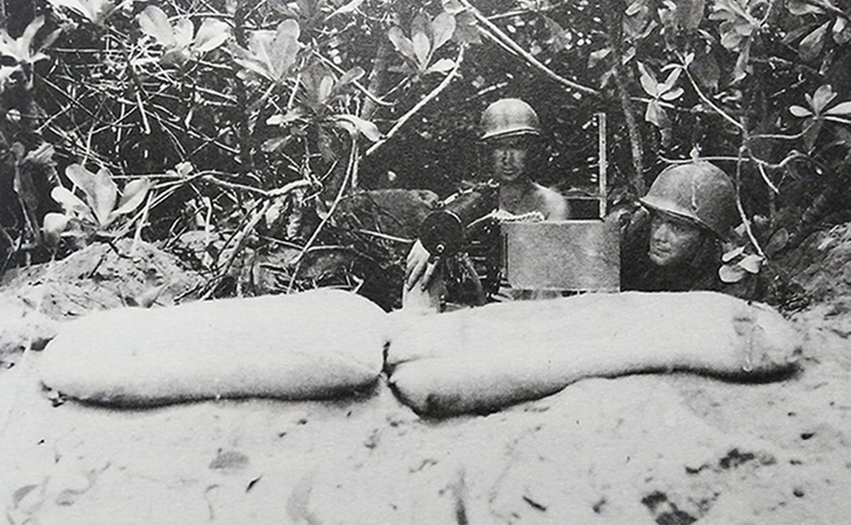 二战太平洋战场岛屿争夺战中，美国海军陆战队一挺M1917A1水冷式重机枪在两个沙袋构筑的临时工事中作好战斗准备。