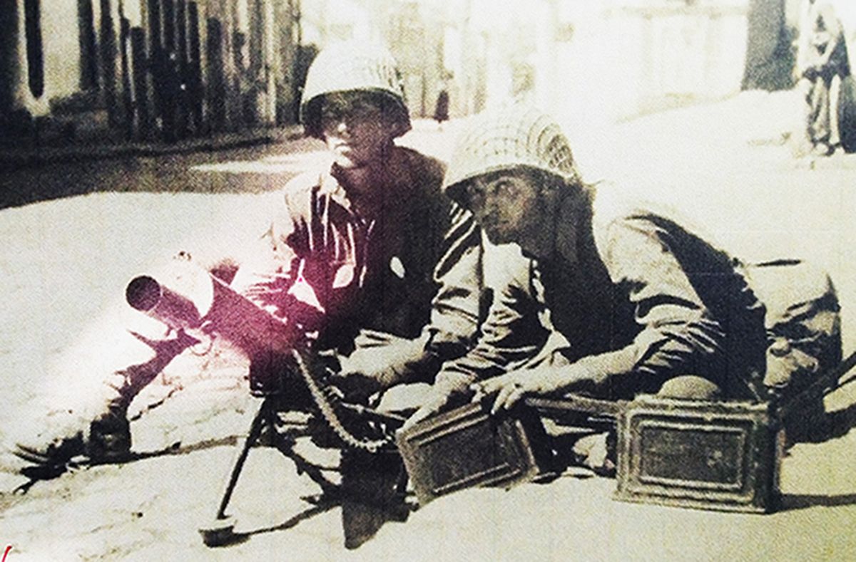 1944年8月，「诺曼底登陆」期间，西线法国战场，美军第5步兵师一名士兵将一挺M1917A1水冷式重机枪架在路上准备战斗，机枪配备的弹药箱内是250发弹链（该型机枪以250发弹链供弹，每隔4发子弹就有一发红头曳光弹作射迹显示）。
