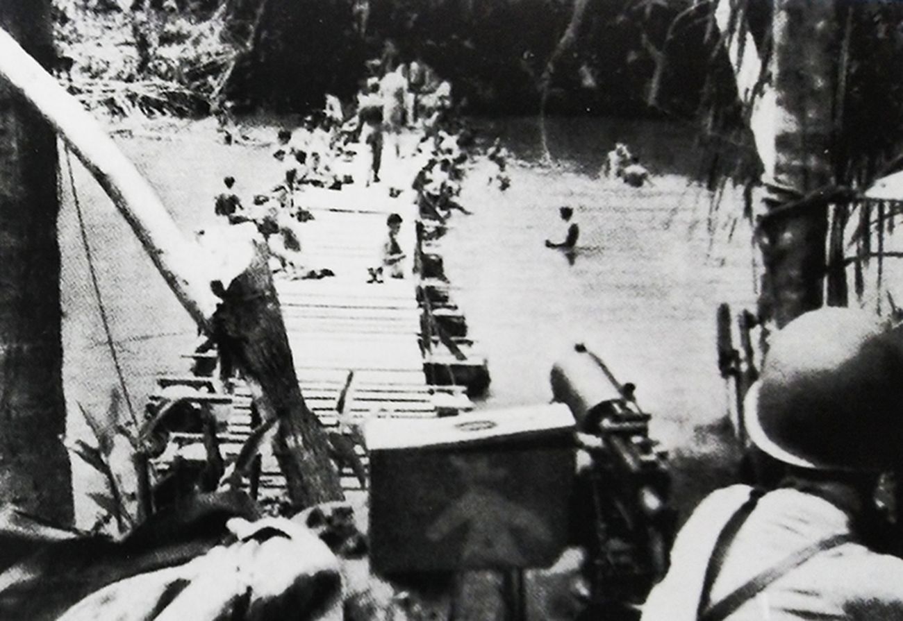 1942年8月，「瓜岛战役」期间，太平洋战场，登陆瓜达尔卡纳尔岛的美国海军陆战队一挺M1917A1水冷式重机枪正为搭建临时人行浮桥、在浮桥两侧洗澡的士兵作掩护。