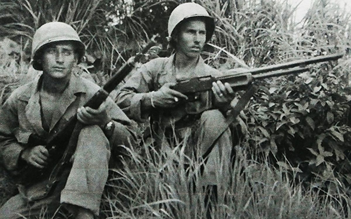 1945年，太平洋战场，两名美国海军陆战队士兵在草丛中警惕地注视前方。右边一名士兵手持M1918A2「勃朗宁」自动步枪，该枪优点是故障少、射击威力大。