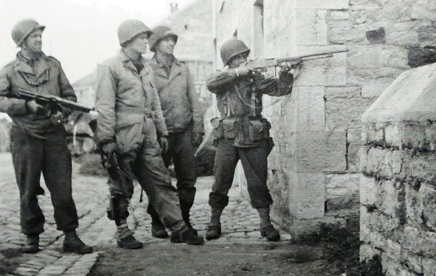 1945年，「阿登反击战」期间，西线战场比利时哈尔兹，一名美军士兵用M1918A2「勃朗宁」自动步枪向隐藏在远处房屋内的德军狙击手射击。
