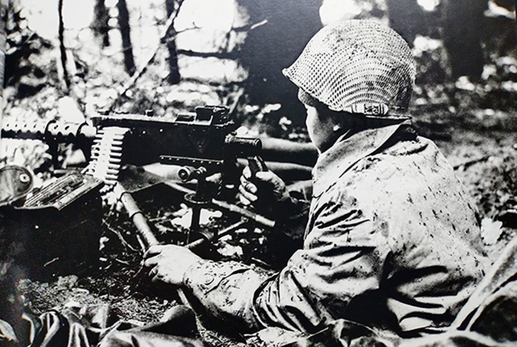 二战战场上，美军一名机枪手正操纵一挺M1919A4重机枪向敌军射击。
