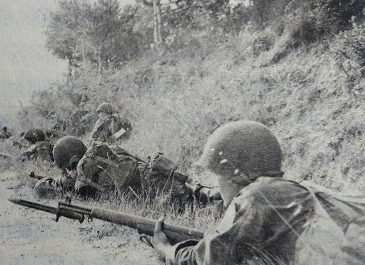 1944年，西线战场，美军士兵埋伏在路边准备战斗，图中一名士兵紧张地握着一支上了刺刀的M1「加兰德」半自动步枪，随时准备近身拼刺。