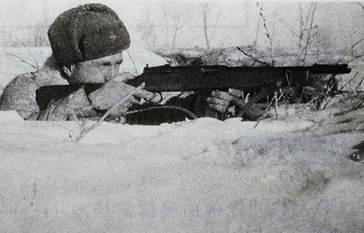 二战东线战场，一名苏军士兵埋伏在雪地里，手持美国按租借法案援助的赖辛冲锋枪向德军射击。