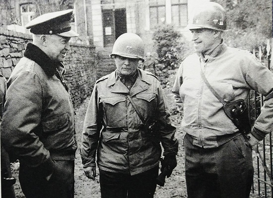 1944年12月,「阿登反击战」期间,西线战场,艾森豪威尔上将(左)到比利时视察,与美军第12集团军群司令布莱德雷中将(右)和第9步兵师师长克雷格少将(中)交谈。这三名美军高级军官身上配备的都是M1911半自动手枪。