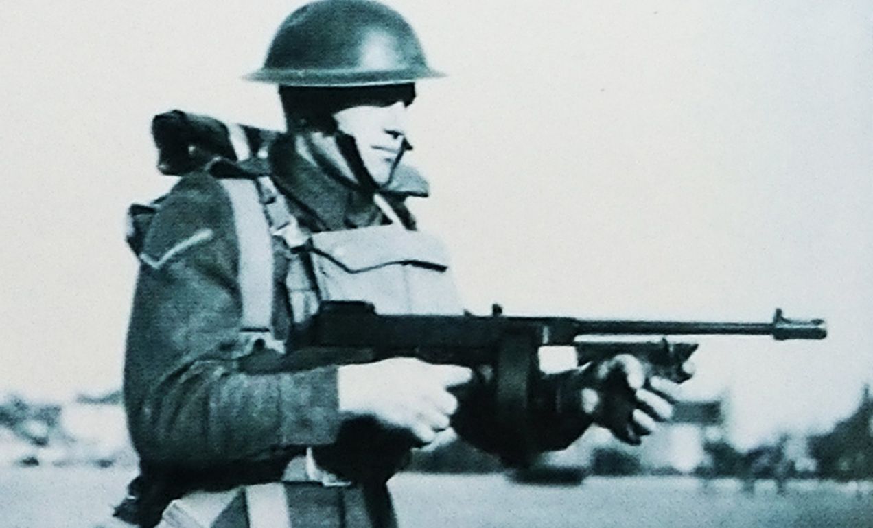 一名英军士兵手持M1928汤普森冲锋枪冲锋。