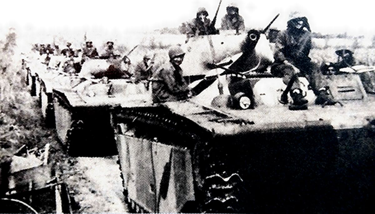 1945年4月，「冲绳岛战役」期间，美军一队安装有75毫米短筒火炮的LVT4两栖装甲车正向岛内战场进发。