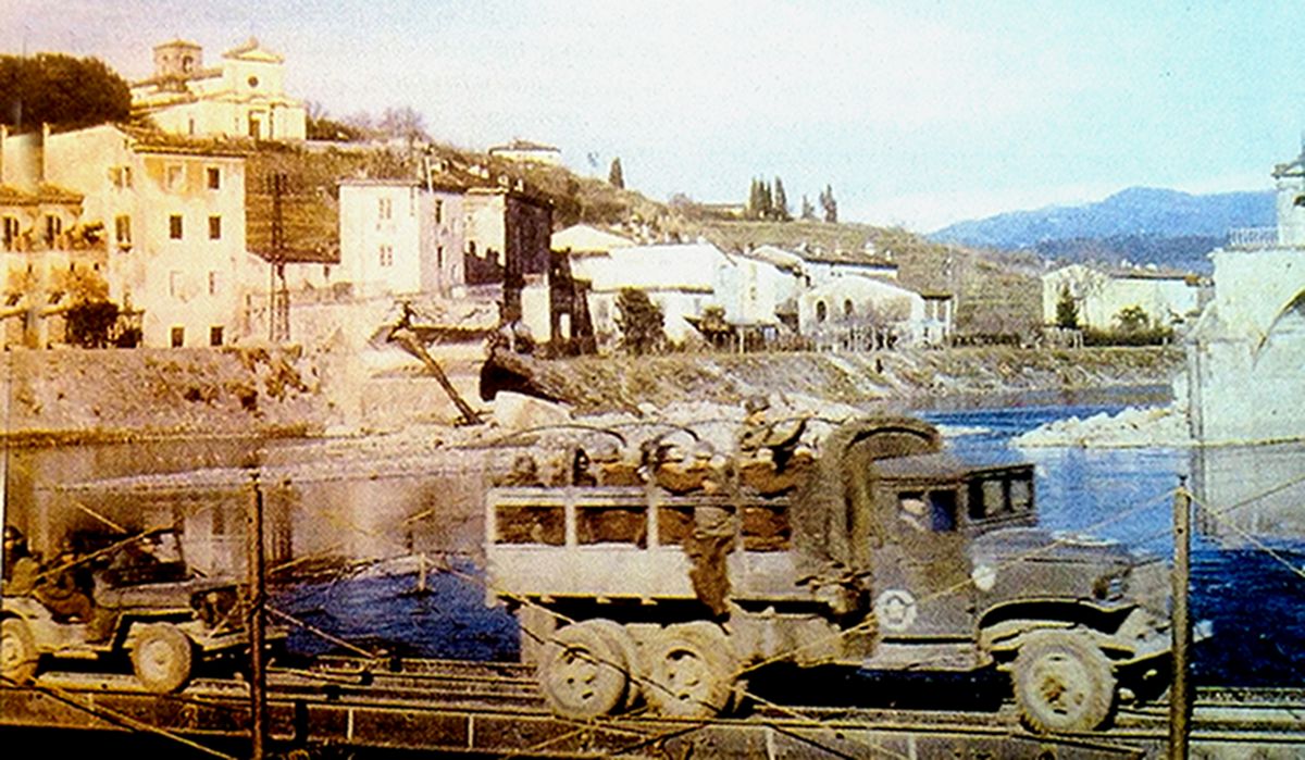 1944年9月,美军的一辆GMC CCKW 353型卡车装载着一车士兵正驶过意大利塞尔基奥河上的桥梁。
