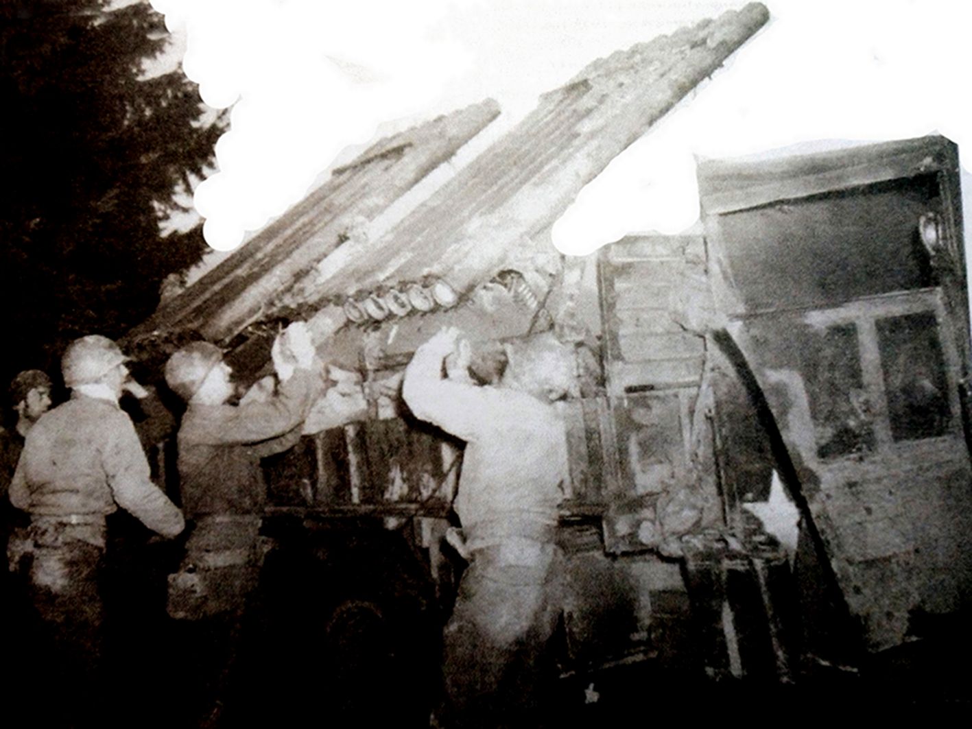 1944年西线战场,美军第18野战炮兵营一辆用GMC CCKW 353型卡车改装的火箭炮车,车上安装了T27型多管火箭炮,图中炮兵们正在向火箭炮装填炮弹。