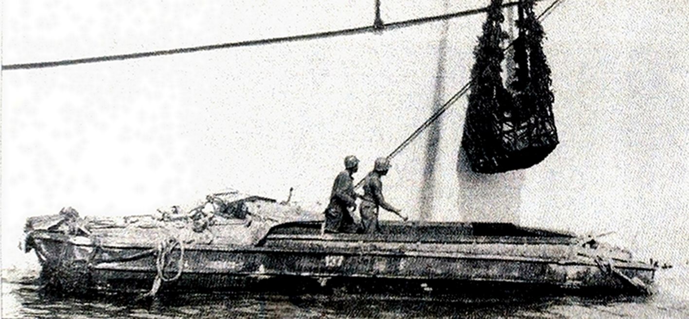 1944年8月，「龙骑兵行动」期间，西线战场法国南部，一艘大型运输舰正通过绳网将物资吊装到一辆通用DUKW353轮式两栖运输车上。
