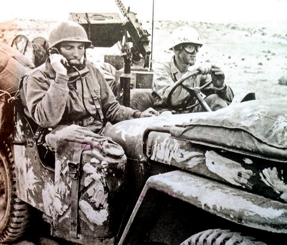 1943年3月23日,「突尼斯战役」期间,盖塔尔(El Guettar)地区附近战斗中,美军第1步兵师的一名战地指挥官坐在一辆威利吉普车上用电话向下属发出指令。