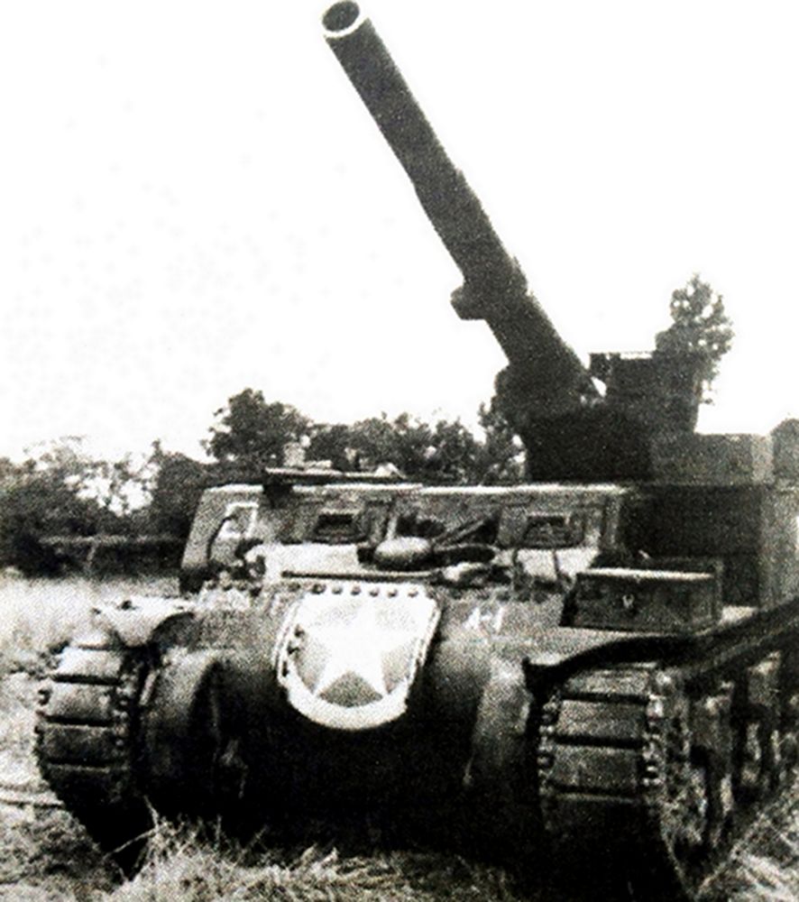 1944年7月，「诺曼底登陆战役」期间，西线战场法国诺曼底地区，美军第987装甲野战炮兵营的一辆M12自行火炮，该炮车的155毫米榴弹炮的炮身已抬至最高仰角。