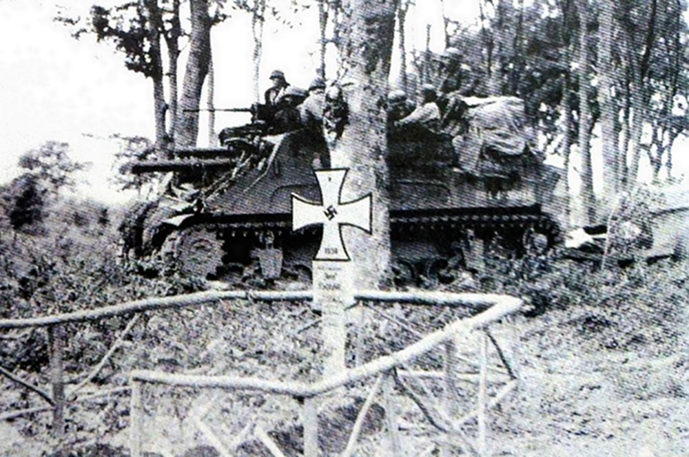1944年7月底，「眼镜蛇行动」期间，美军一辆M7自行火炮的炮组正从一个公墓旁穿过，公墓内有一个德军党卫军军官的墓穴，该炮车后面牵引着一部装载105毫米榴弹炮弹和高射机枪子弹的M8型弹药拖车。
