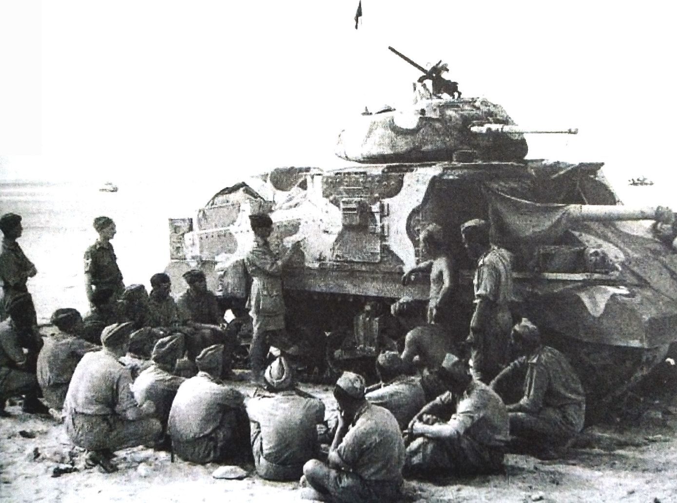 1942年,「阿拉曼战役」期间,一个英军军官正在非洲阿拉曼战场一辆M3中型坦克旁讲解(坦克结构或战术问题)。