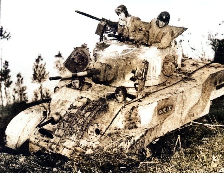 1944年11月29日,在意大利Capua地区,一辆正在执行任务的美军M5A1轻型坦克不慎陷入淤泥中,其车组成员正想法脱离困境。该坦克车体是涂抹了伪装迷彩的。