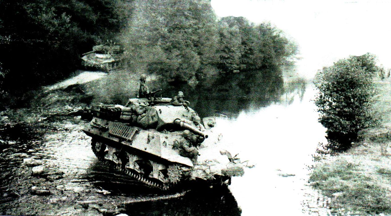 1944年8月,法国中部地区,两辆穿越溪流的M10坦克歼击车。领头这辆M10的传动变速器上仍装配着Culin树篱切割器,这种简易器械专门用于切割诺曼底地区浓密的海岸灌木树丛以开辟前进通道。