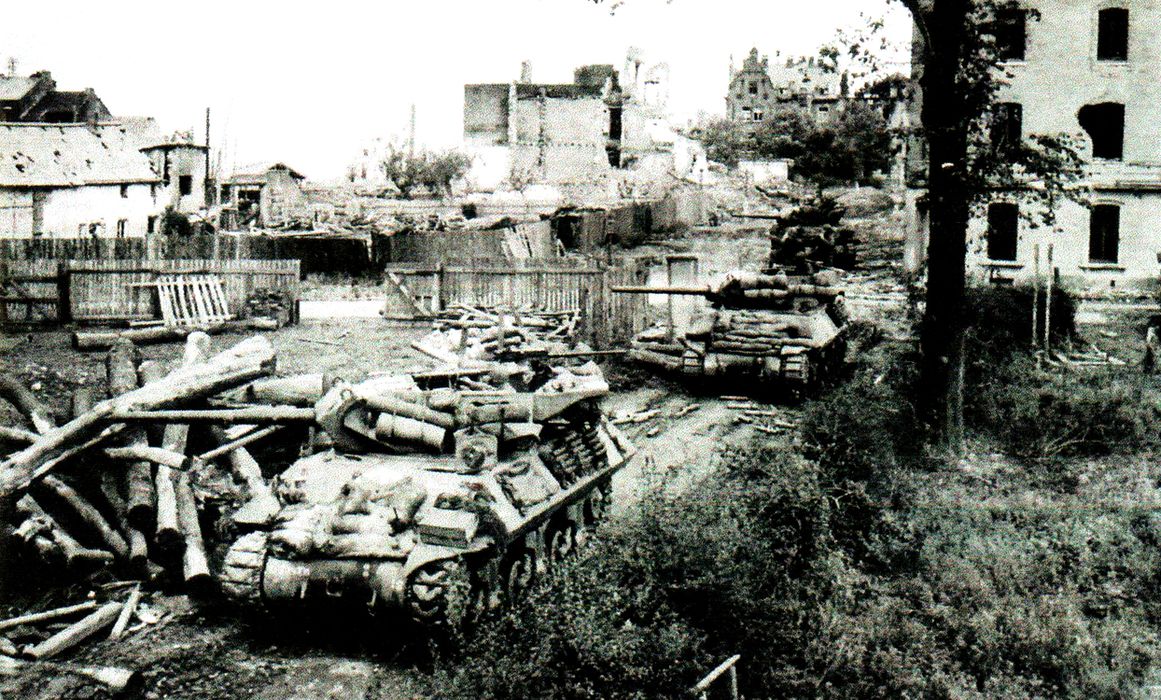 1944年10月14日,「亚琛战役」期间,第603坦克歼击营A连的M10坦克歼击车正在打通德国城市亚琛外围道路。亚琛是盟军部队进入的第一个德国城市,图中这些M10是晚期生产型,采用平衡重量的鸭式布局炮塔,前装甲板上已开始携带沙袋以增强对抗德军反坦克火箭筒的防护能力。
