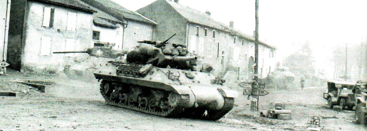 1944年11月17日,「梅斯战役」期间,美军第712坦克歼击营一辆名为「帕杜卡呕吐(Puke of Paduka)」的M10坦克歼击车正通过法国梅特泽尔维斯地区,前往马其诺防线附近支援第90师。该部队在11月14日试图清除摩泽尔河东岸要塞城市梅斯的防御工事,在穿越摩泽尔河两天之前,其击退了德军第25装甲掷弹兵师的一支装甲部队攻击。
