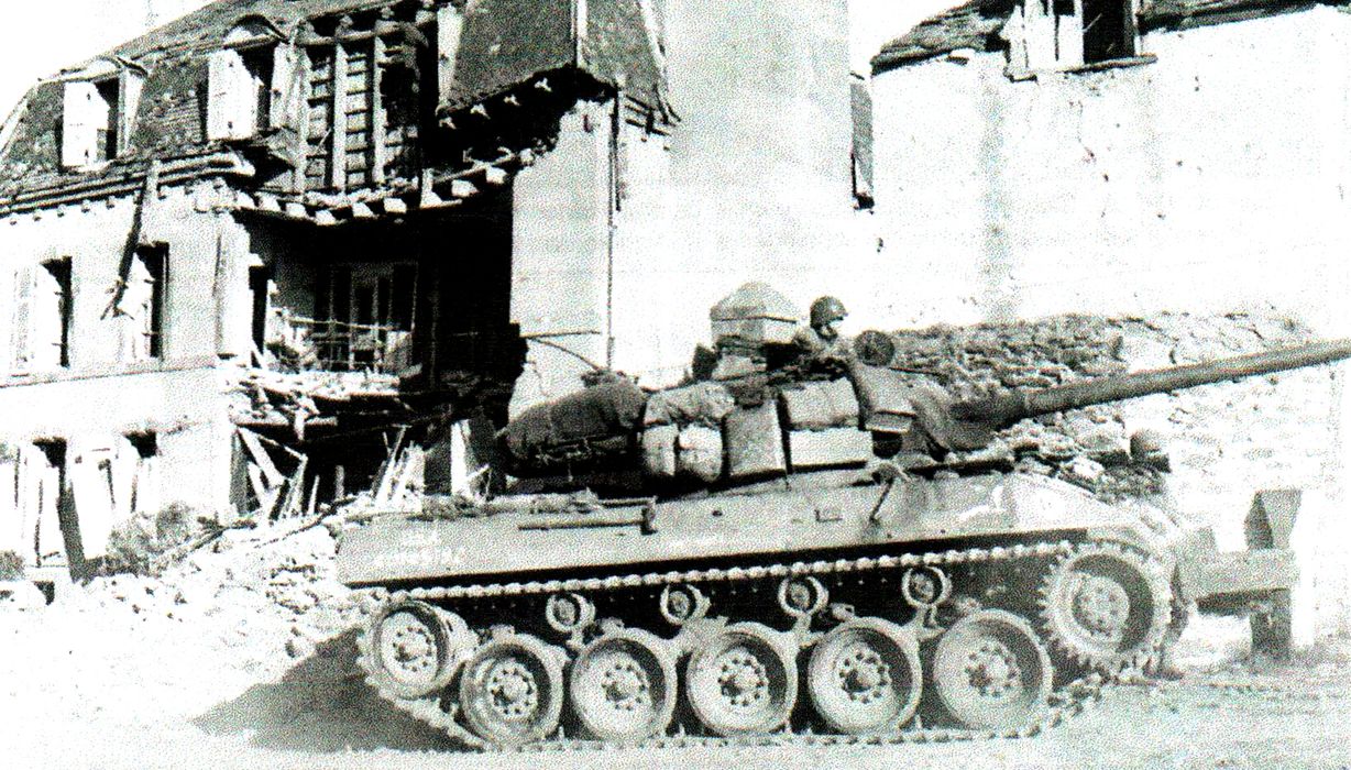 1944年9月12日,「布雷斯特战役」期间,停靠在法国布雷斯特外围地区一座废墟旁的美军M18「地狱猫」坦克歼击车,其炮塔后部堆满的背包、铺盖和其它配载品也是M18的特色之一,这是缘于M18内部空间过于狭窄,无法放入太多的车组人员装备。另外,这辆车前部还安装了Culin树篱切割器。
