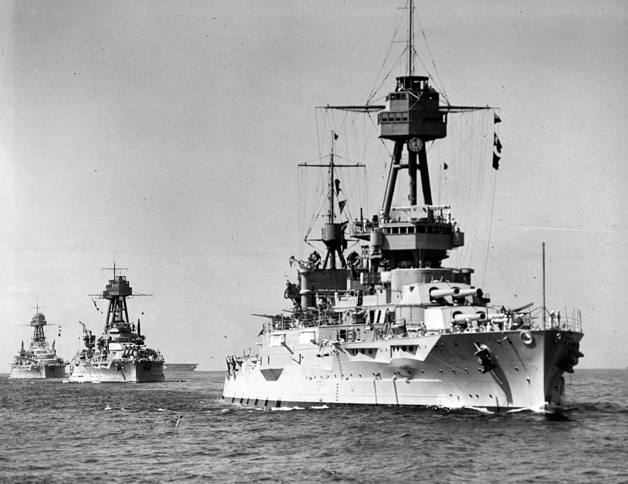 1932年,在演习中领航的美国海军「纽约」号战列舰(BB-34),其后跟随的是「内华达」号(BB-36)和「俄克拉荷马」号(BB-37)战列舰。远处可见「兰利」号航空母舰(CV-1)的部分舰体。