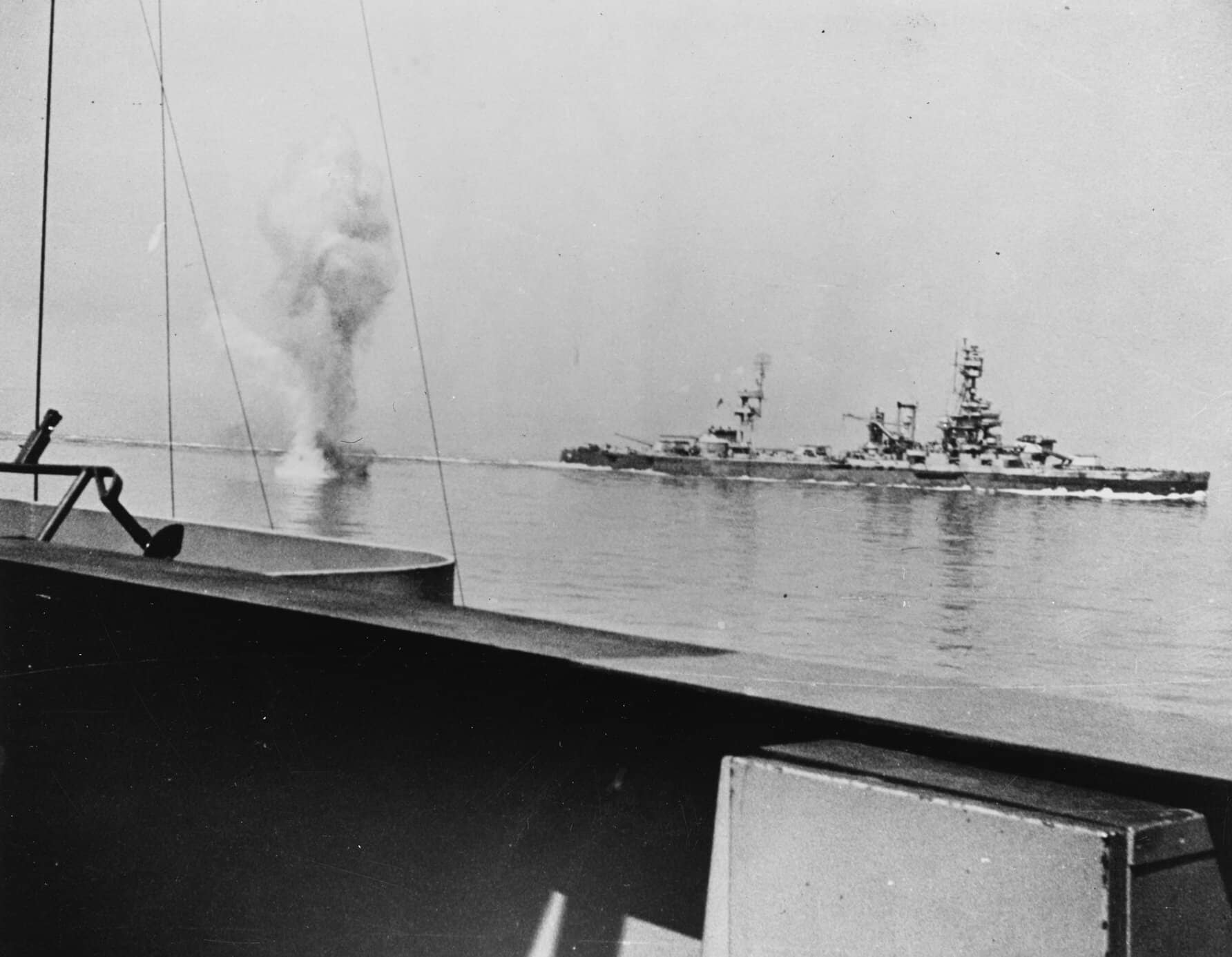 1944年6月25日，瑟堡外海，「阿肯色」号（BB-33）与「得克萨斯」号（BB-35）战列舰炮击德军「汉堡」炮台时，一枚德军岸炮炮弹在两舰之间爆炸。照片即自「阿肯色」号甲板拍摄。