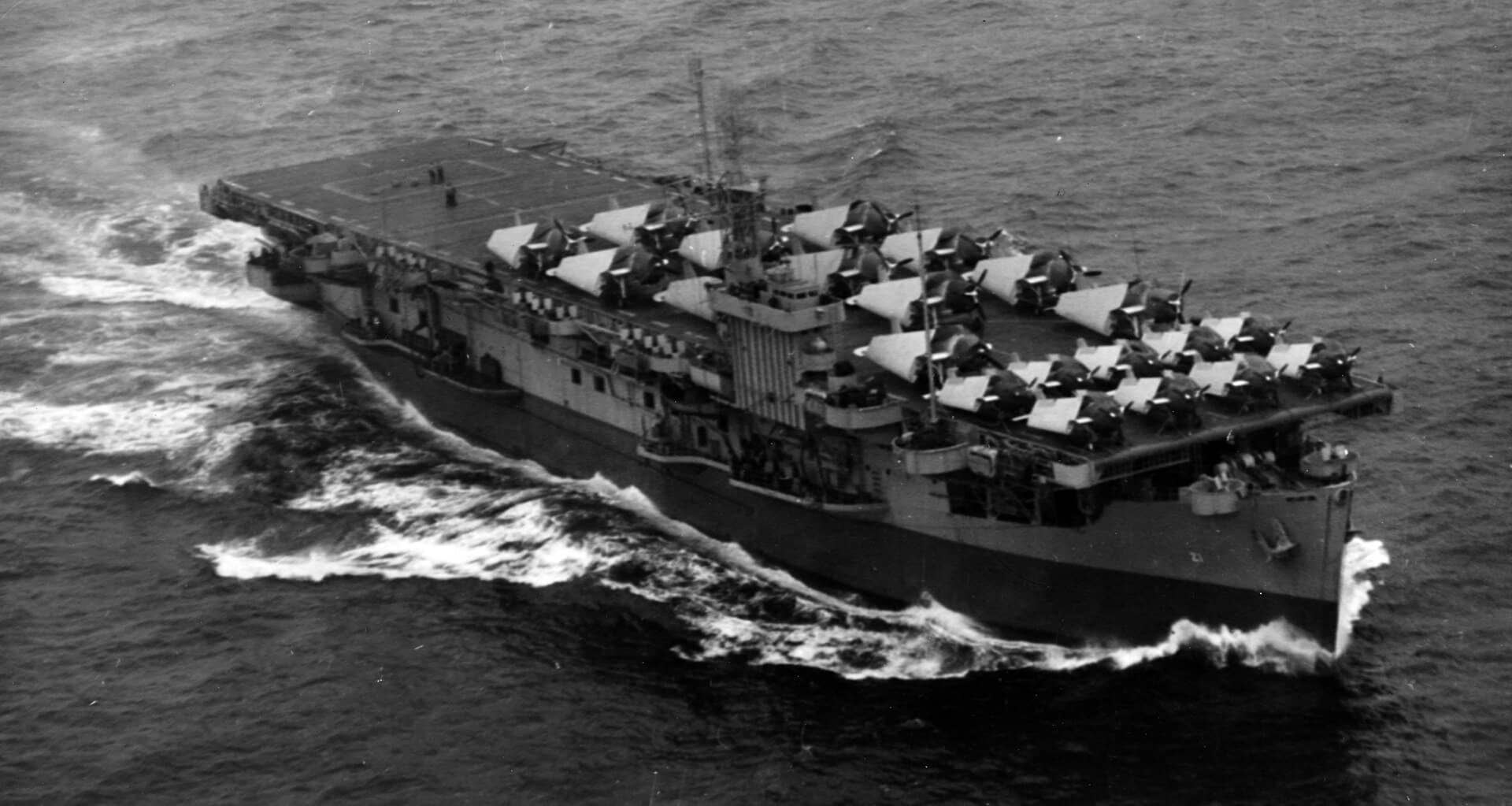 1943年10月15日,离开诺福克、航行于切萨皮克湾口外大西洋海域的美国海军「布洛克岛」号护航航空母舰(CVE-21)。当时,该舰正启程执行首次反潜巡逻任务,甲板上搭载着第1混合中队(VC-1)的各型战机,包括:9架通用汽车公司生产的 FM-1「野猫」战斗机(位于飞行甲板前方)以及12架格鲁曼 TBF-1C「复仇者」鱼雷轰炸机。注:这张照片由第14飞艇中队(ZP-14)的一艘飞艇所拍摄。