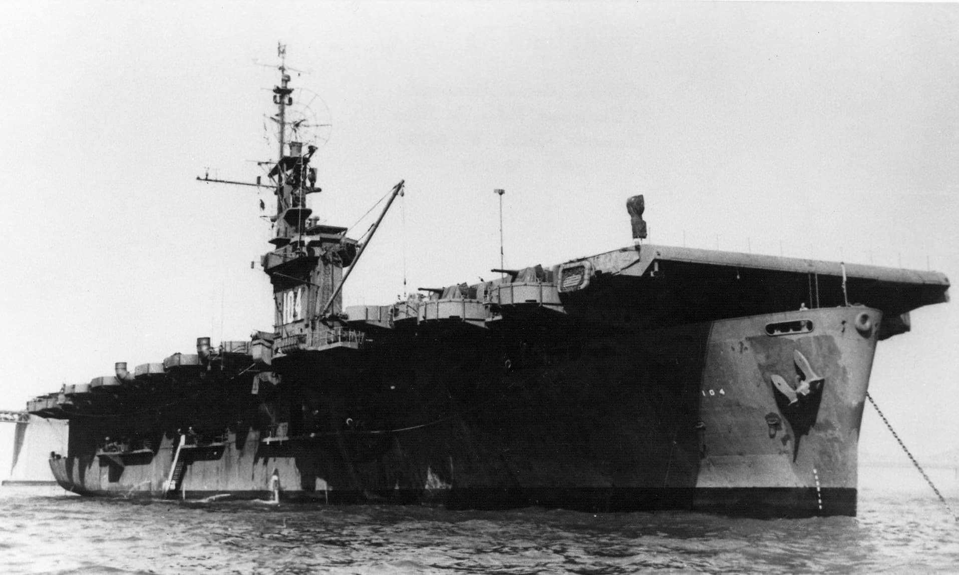 1945年,最后一艘下水服役的卡萨布兰卡级护航航母「蒙达」号(USS Munda,CVE-104)停泊在旧金山湾内。请注意其舰岛上已涂上了二战之后方才常见的巨大舷号标记。注:由于美军强大的战时生产力,不少卡萨布兰卡级护航航母在服役后承担的多是运输补给和训练飞行员等支援型任务,「蒙达」号也不例外。在二战后期,其主要配合美国海军第30.8特混大队(Task Group 30.8)行动,自身并未有太多战斗任务。