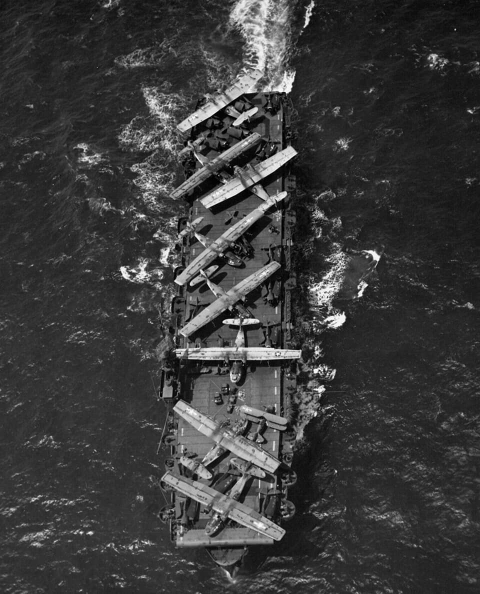1944年7月间,正驶往加利福尼亚州阿拉米达海军航空站(NAS Alameda)的美国海军卡萨布兰卡级护航航空母舰「西蒂斯湾」号(USS Thetis Bay,CVE-90)护航航空母舰。其甲板上装载着一批历经战火、显得十分破旧的飞机。甲板上可见的飞机包括:8架联合 PBY「卡特琳娜」水上飞机、18架格鲁曼 F6F「地狱猫」战斗机,以及1架格鲁曼 J2F「鸭」水路两栖双翼机。