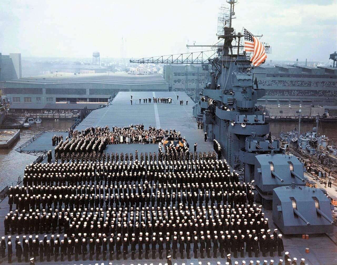 1943年4月15日,在美国弗吉尼亚州诺福克海军造船厂举行的约克城号航空母舰(USS Yorktown,CV-10)服役仪式。此时约克城号刚换上了「21号迷彩方案」(Camouflage Measure 21)。在右侧码头的另一边,停泊着两艘钢制船体的反潜巡逻艇(PC)。