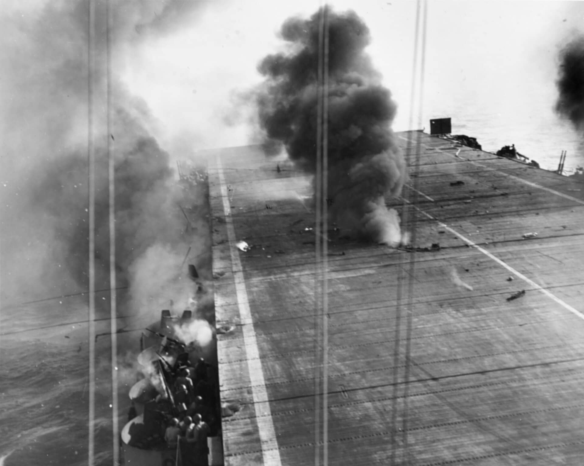 1944年10月25日,「苏万尼」号护航航母(CVE-27)被一架日本 A6M5「零」式自杀攻击机命中,该机携带的250公斤炸弹在飞行甲板与机库甲板之间爆炸,烈焰随之喷涌而出。注:当时「苏万尼」号在「莱特湾战役」中担任登陆编队的护航航母,其在10月25日-26日这两天内连续遭到两次「神风」特攻机的自杀式攻击,这两次袭击导致「苏万尼」号107人死亡,160人受伤。